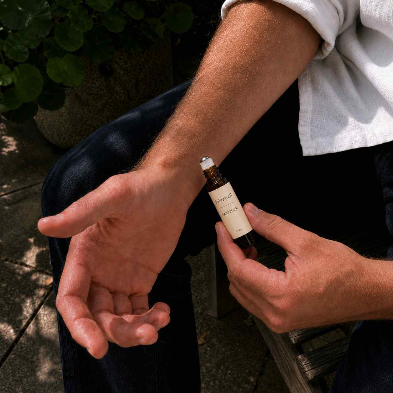 Men applying Sanctum 100% natural fragrance to wrist.